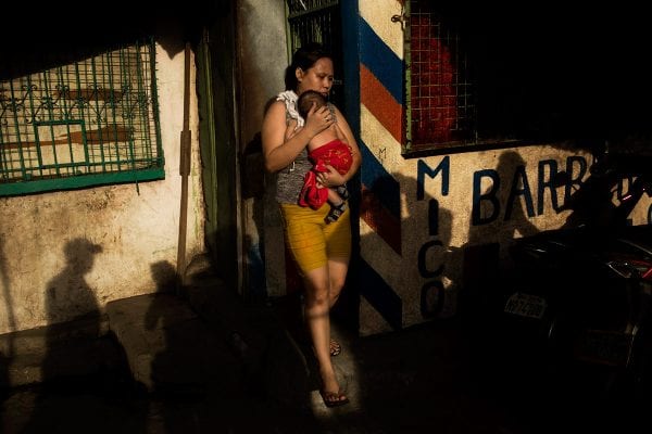 Street photography by Orna Naor. Woman carrying baby in the Philippines.