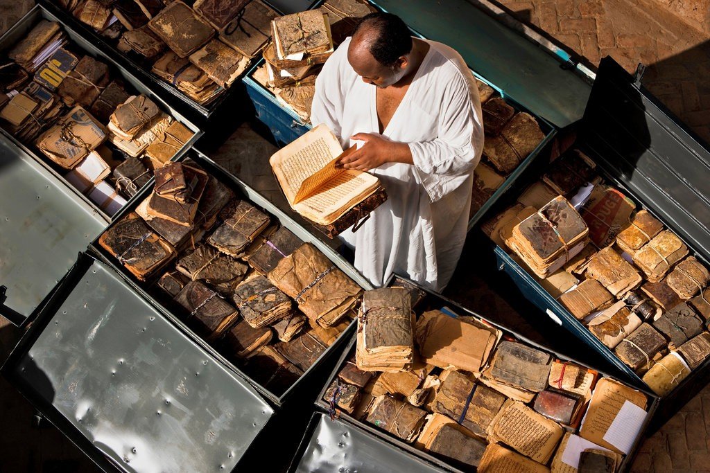 Aerial photograph of a man reading the Manuscripts of Timbuktu, Mali, 2009 by Brent Stirton