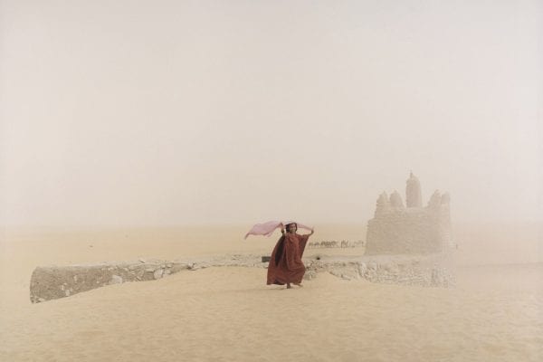 Color photography person with red clothes in desert Mali