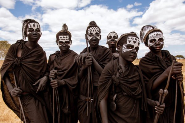 Color photo of children with painted faces in Tanzania by Tamara Arranz