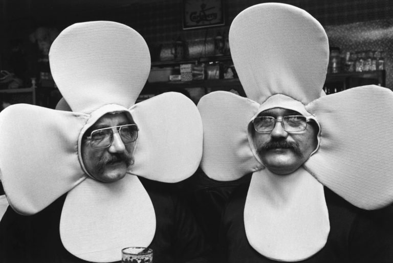 Black and white street photography by Richard Kalvar, two men dressed as flowers in La Louviere, Belgium.