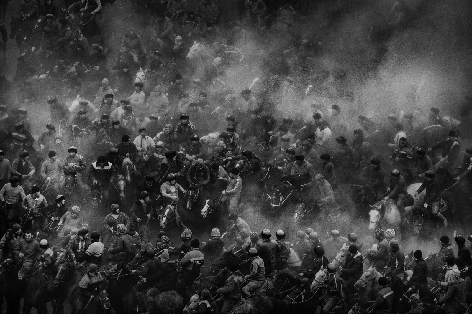 black and white photograph by Alain Schroeder shot In the village of Uzgen, Kyrgyzstan where more than 170 horses and men are playing Kok Boru.