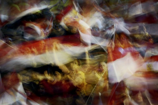 Color photo by Laura El-Tantawy from IN THE SHADOW OF THE PYRAMIDS. Women waving flags.Tahir Square, Cairo, Egypt, Revolution