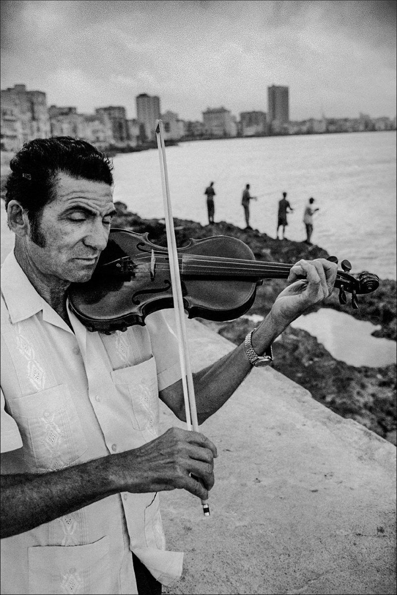 Black and white photo by Xavier Roy. Man playing violin, Havana, Cuba