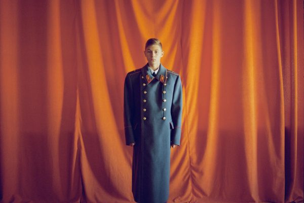 Color portrait of a boy in military uniform by Michal Chelbin