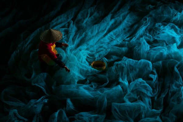 colourful portrait of a Chinese fisherman mending nets by Alex Berger