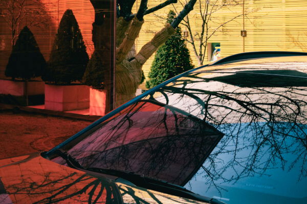 colorful picture of red and yellow buildings with car reflexion by Hansae Lee