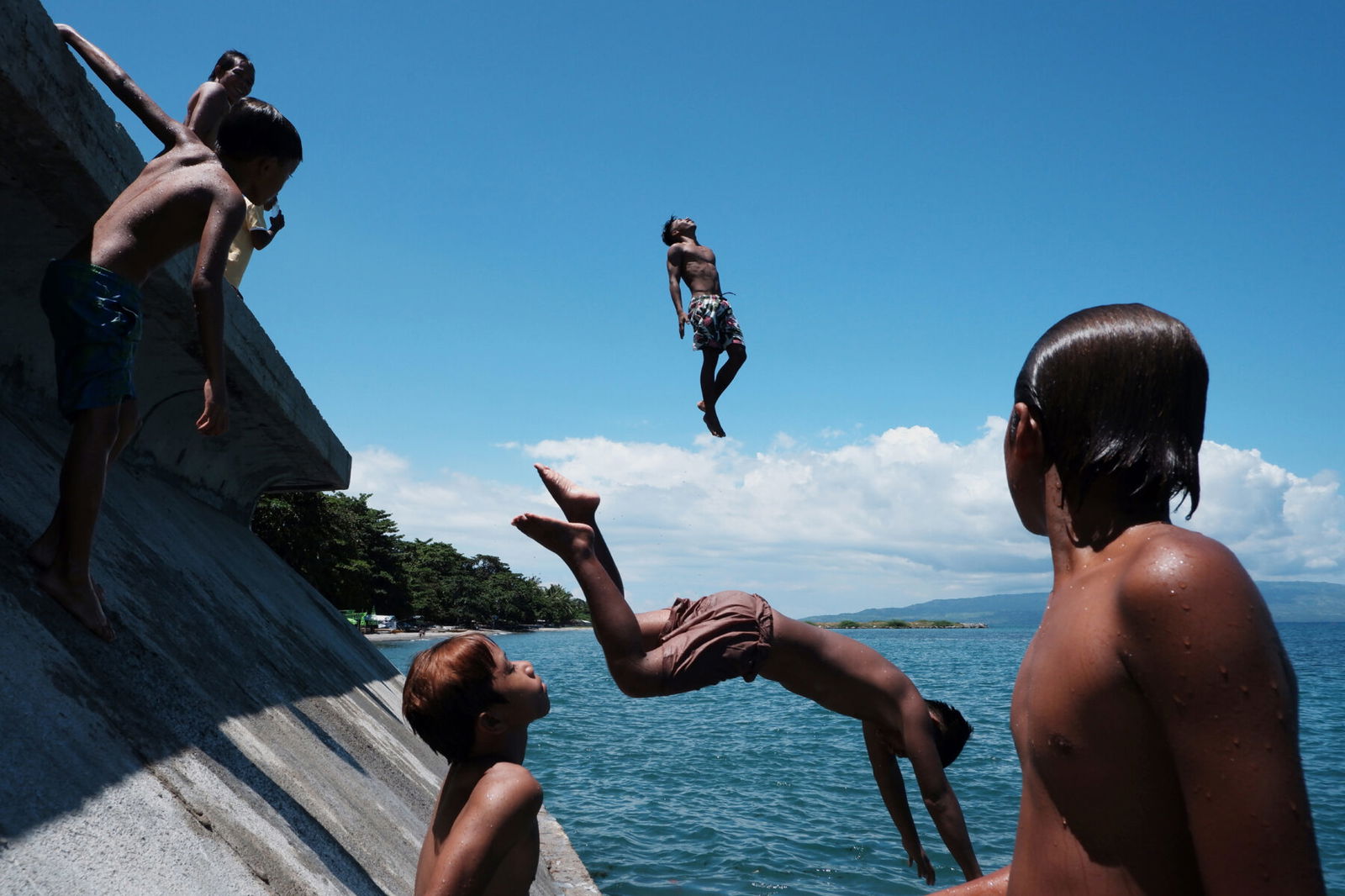 color street pictures of kids diving in Bantayan Beach, Philippines by Hersley Ven Casero