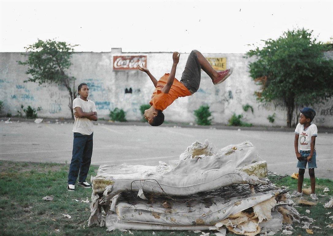 Street photography by Jamel Shabazz, boys flipping on mattress