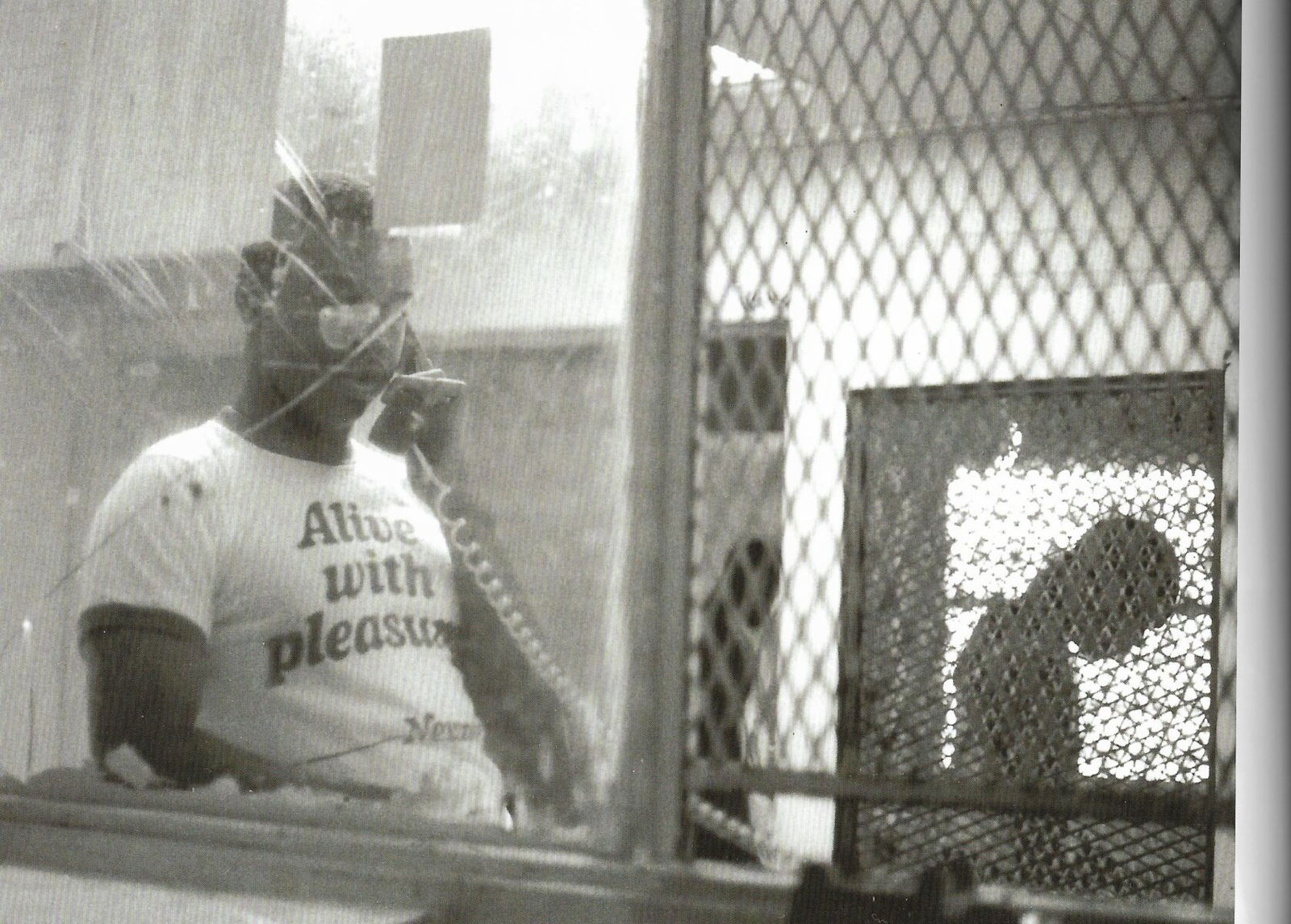 Black and white photography by Jamel Shabazz, man in prison on phone. Rikers Island. 1985