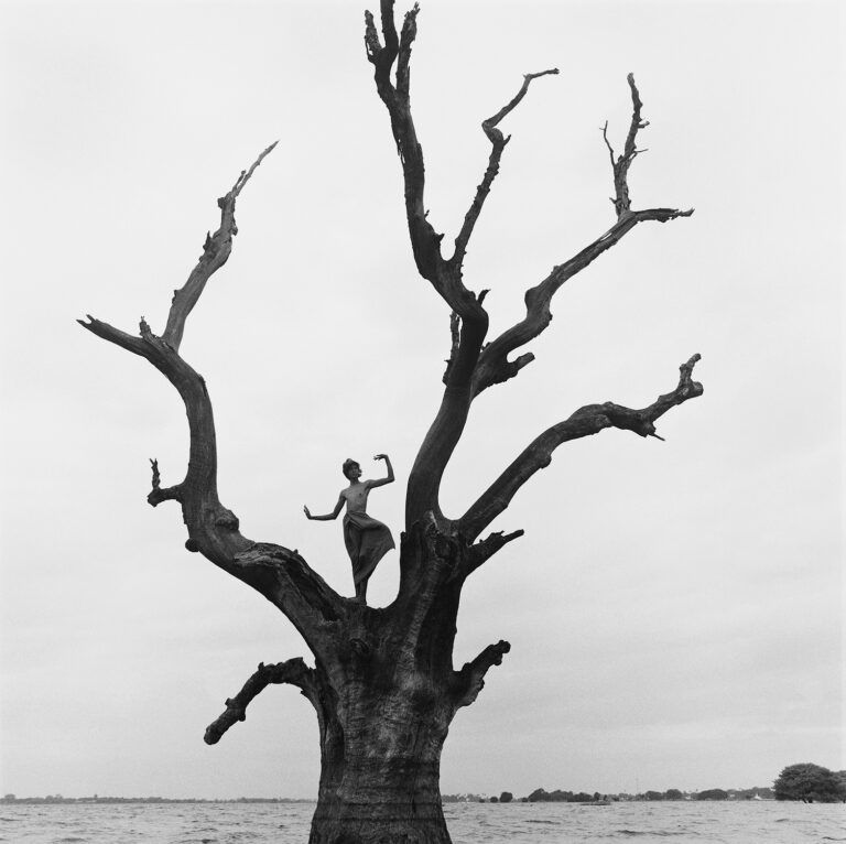 Black & white portrait photography by Monica Denevan, woman dancing on a tree in Burma, Myanmar