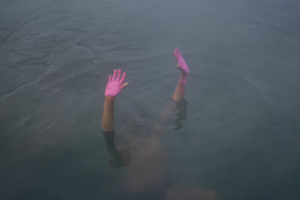 Color photo of boy with pink hands in water by Kin Coedel