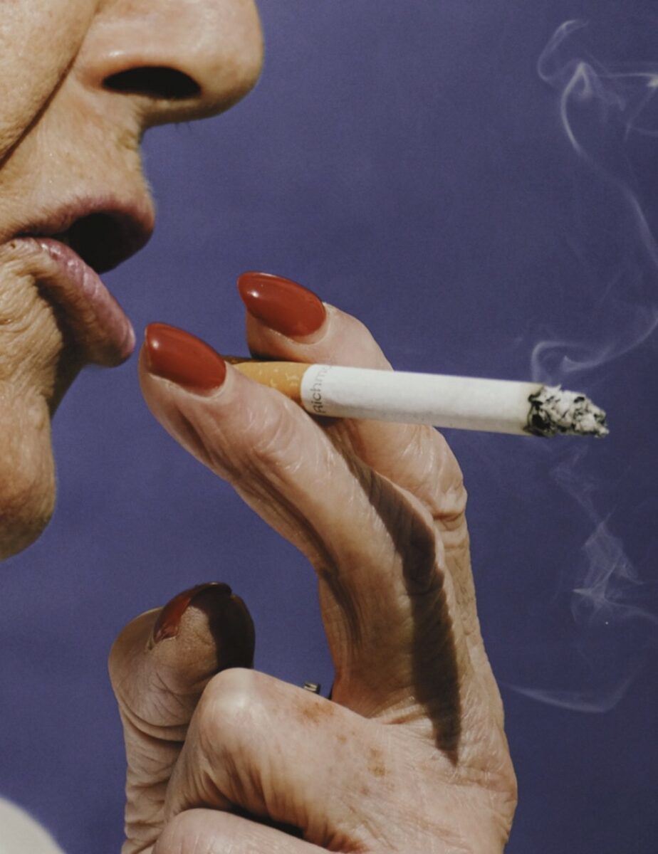 Street photography by Francesco Gioia. Woman smoking with red lips and nails