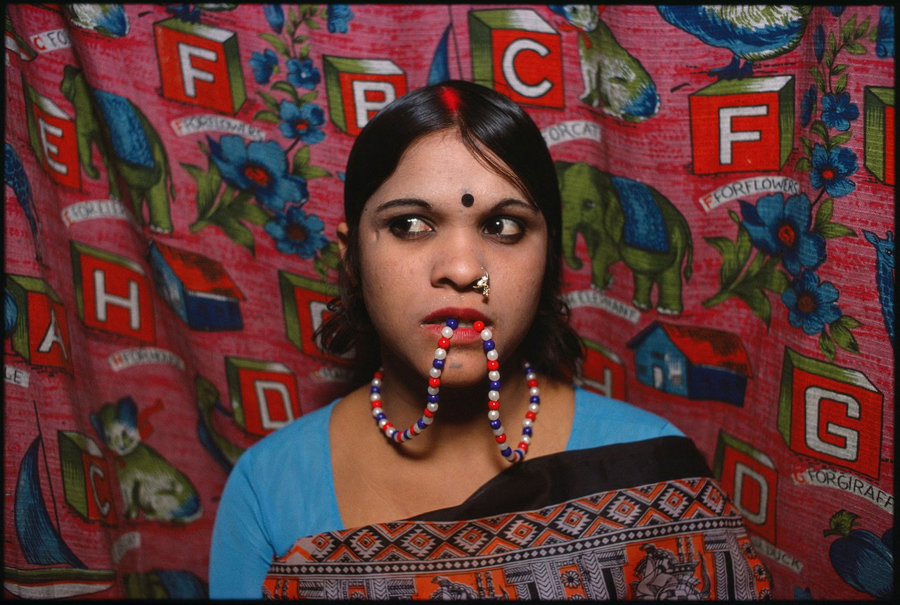 Color portrait photography by Mary Ellen Mark. Indian woman with beads in her mouth