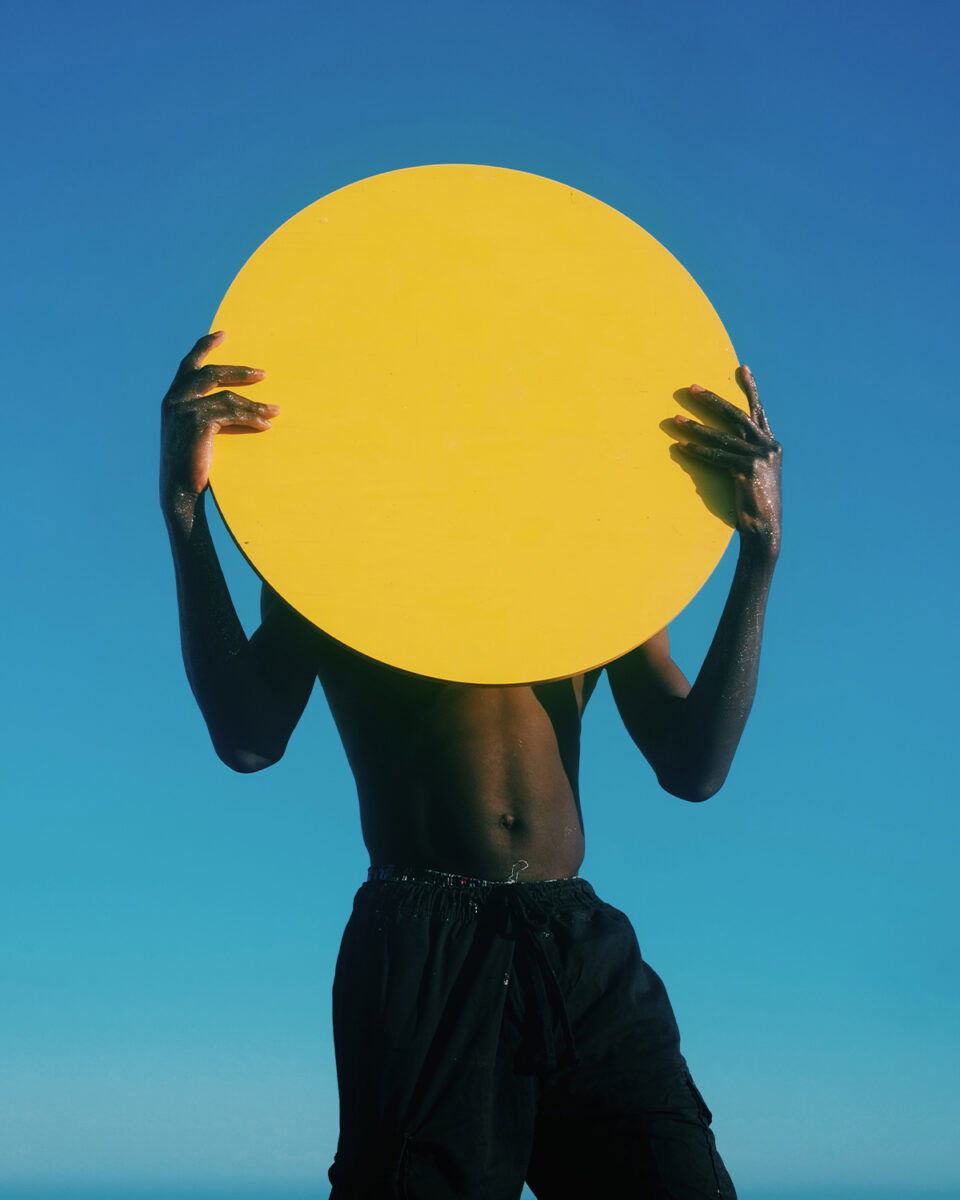 color portrait photo of kid holding yellow disc by Ernesto Sumarkho