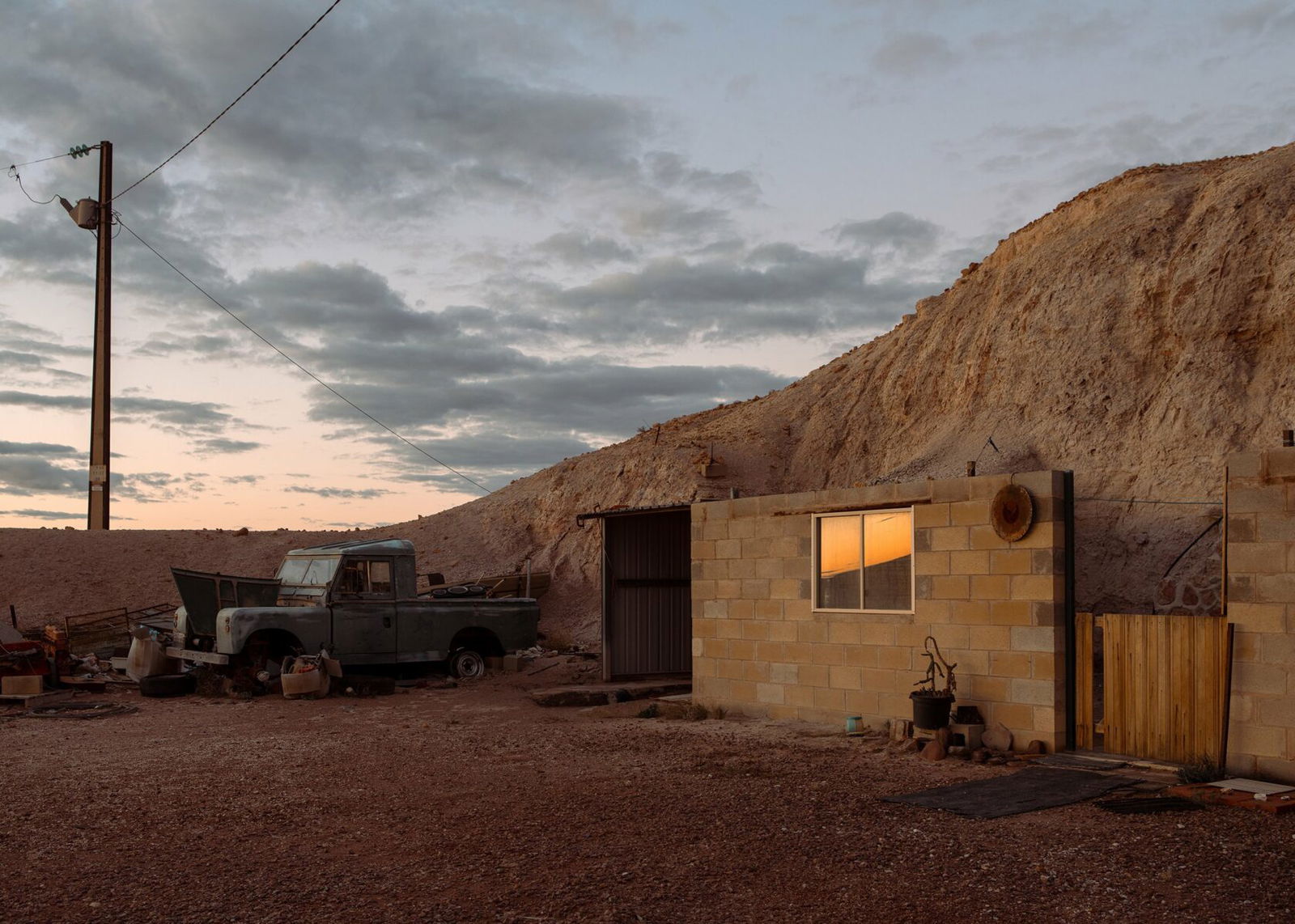 Documentary photography by Mattia Panunzio. Landscape photo of a small house and car at dusk