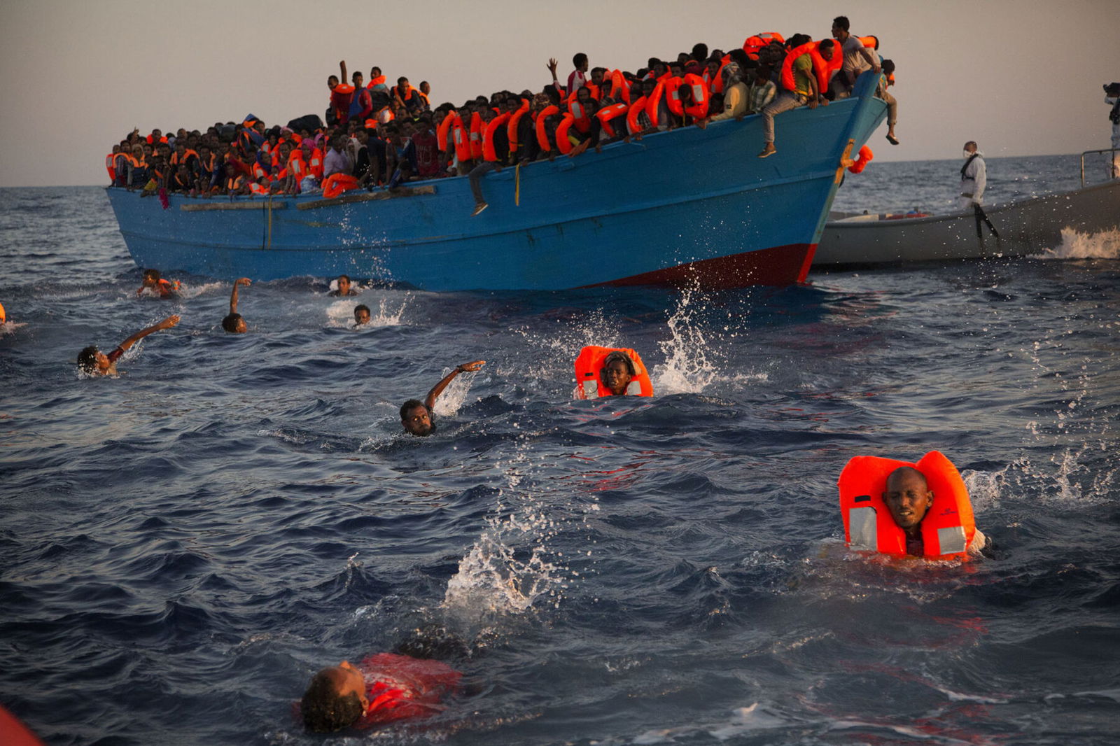 Migrants, mostly from Eritrea, being helped by members of an NGO during a rescue operation.