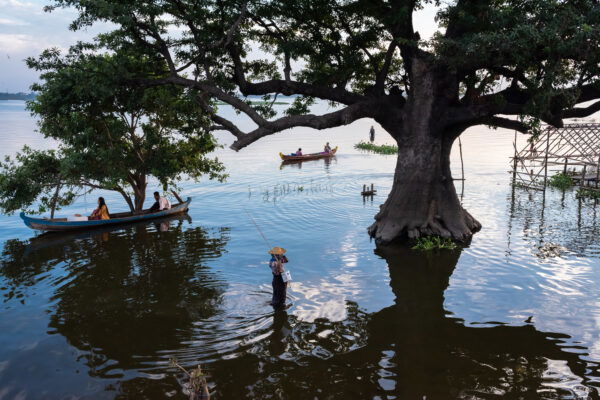 photo of Early evening view of people boating on Lake Taungthaman from the U Bein Bridge, Amarapura, Myanmar by David Keith Brown