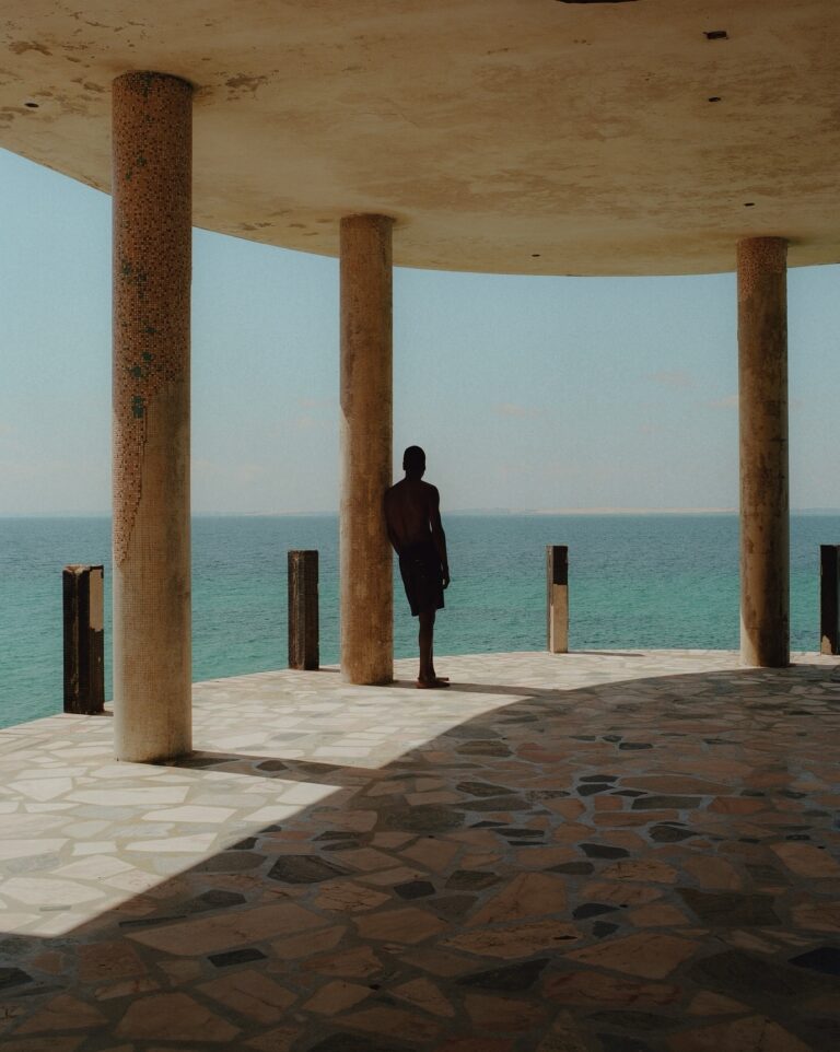 Color photo of men on by the coast in Mozambique by Pie Aerts