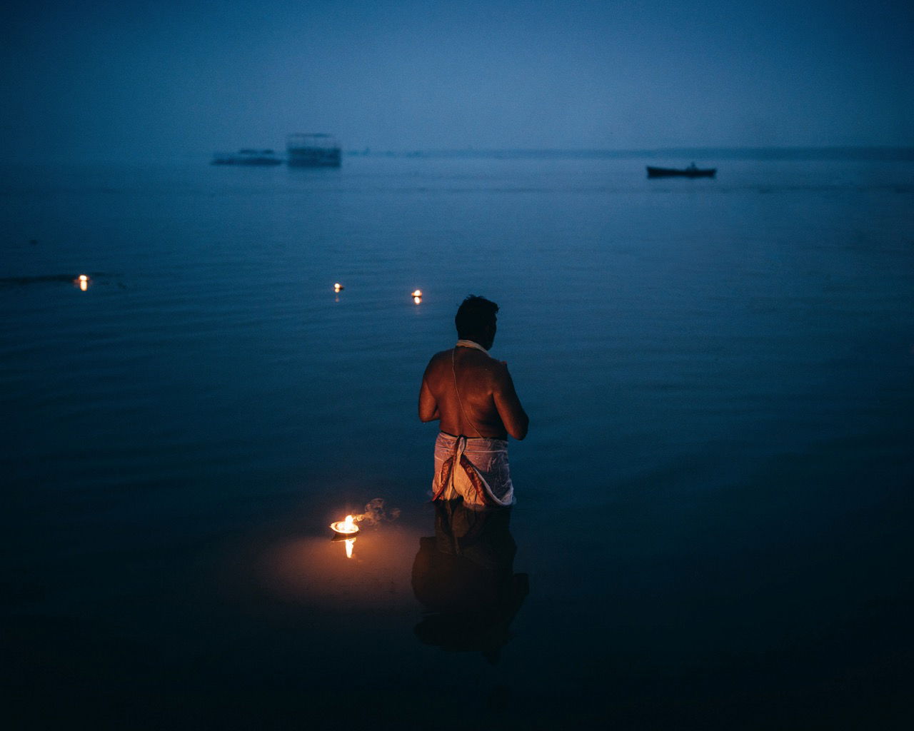 Travel photography by Pie Aerts. A man bathes in the ganges at night - Because People Matter