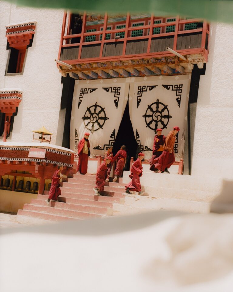 Photo by Pie Aerts from his project Because People Matter. Young Buddhist monks in red clothing play on the steps of a monastery