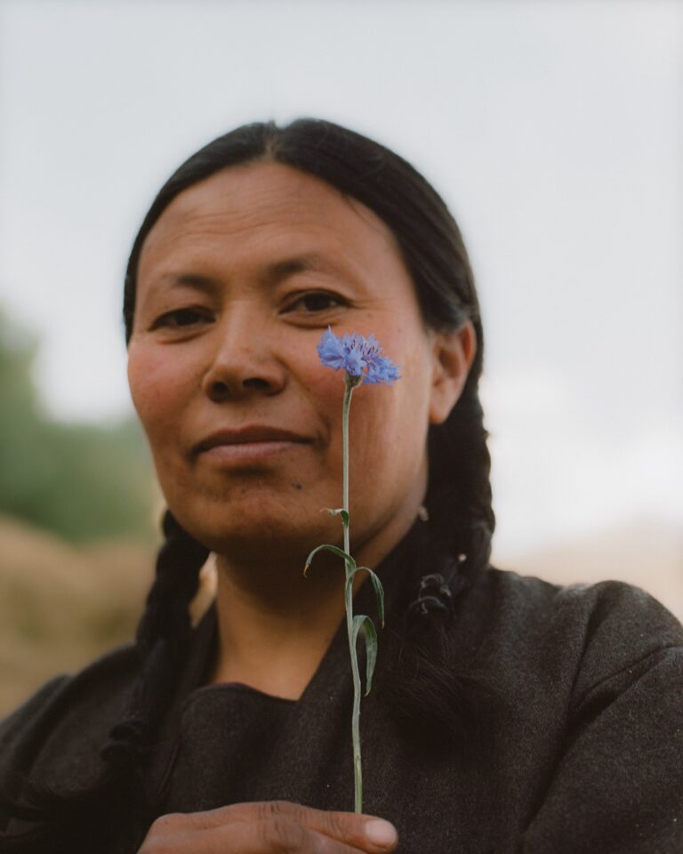 Portrait of a woman holding a blue flower by Pie Aerts