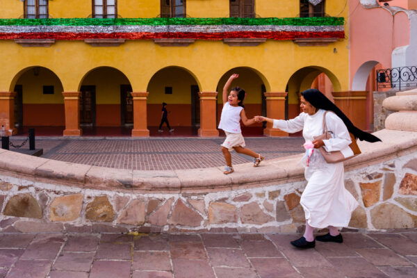 color street photo of child and nun in Mexico by Barry Crosthwaite