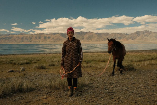 color portrait photo of nomadic woman and horse in western mongolia by Sarah Carrier