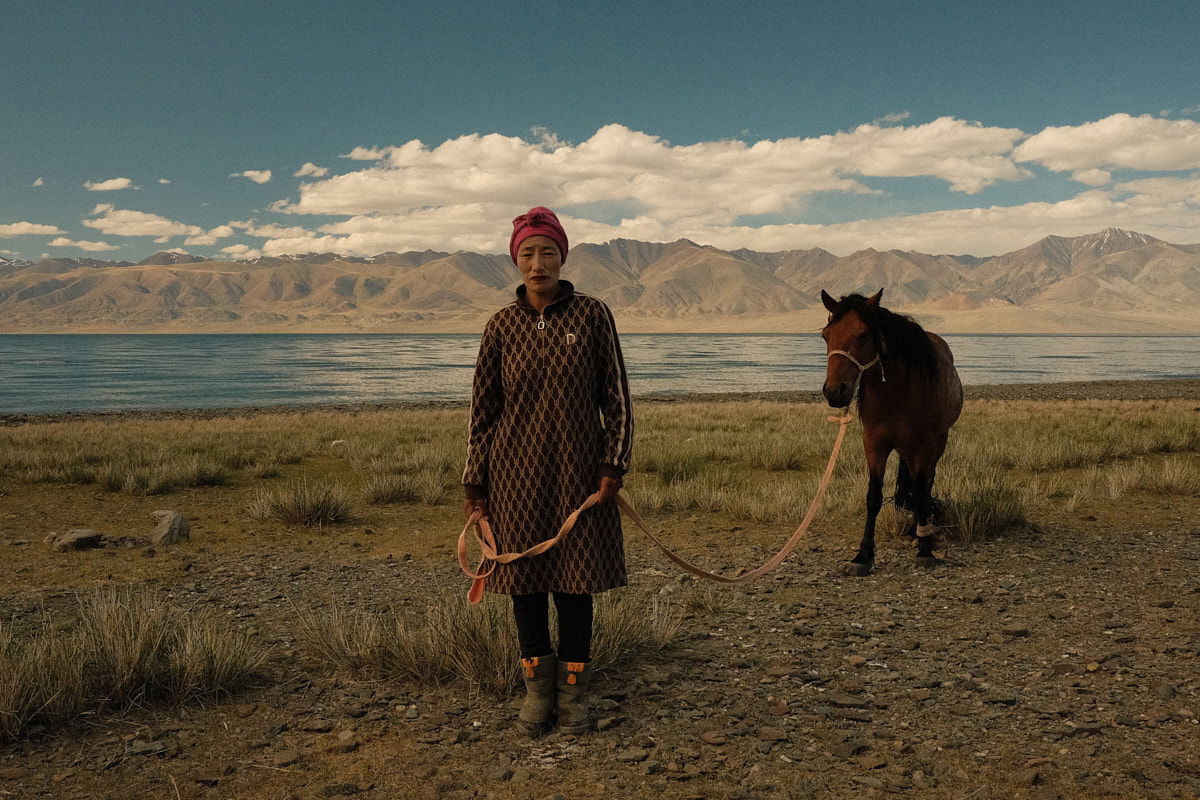 color portrait photo of nomadic woman and horse in western mongolia by Sarah Carrier