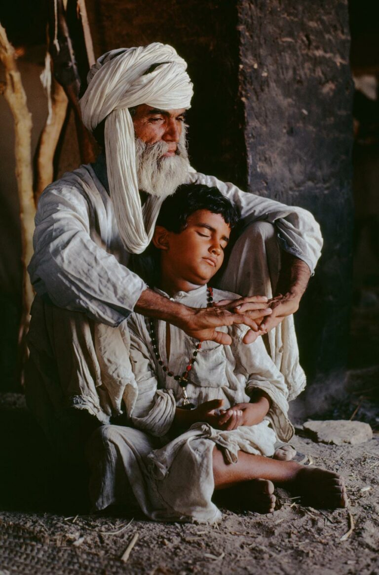 color photo of A father and son at home in Helmand Province, Afghanistan, 1980 by Steve McCurry