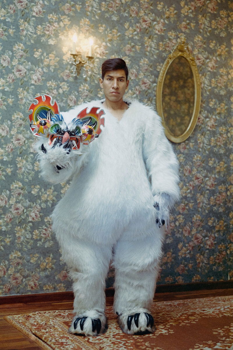 Color portrait photography of a young man in a white bear style outfit by Marisol Mendez