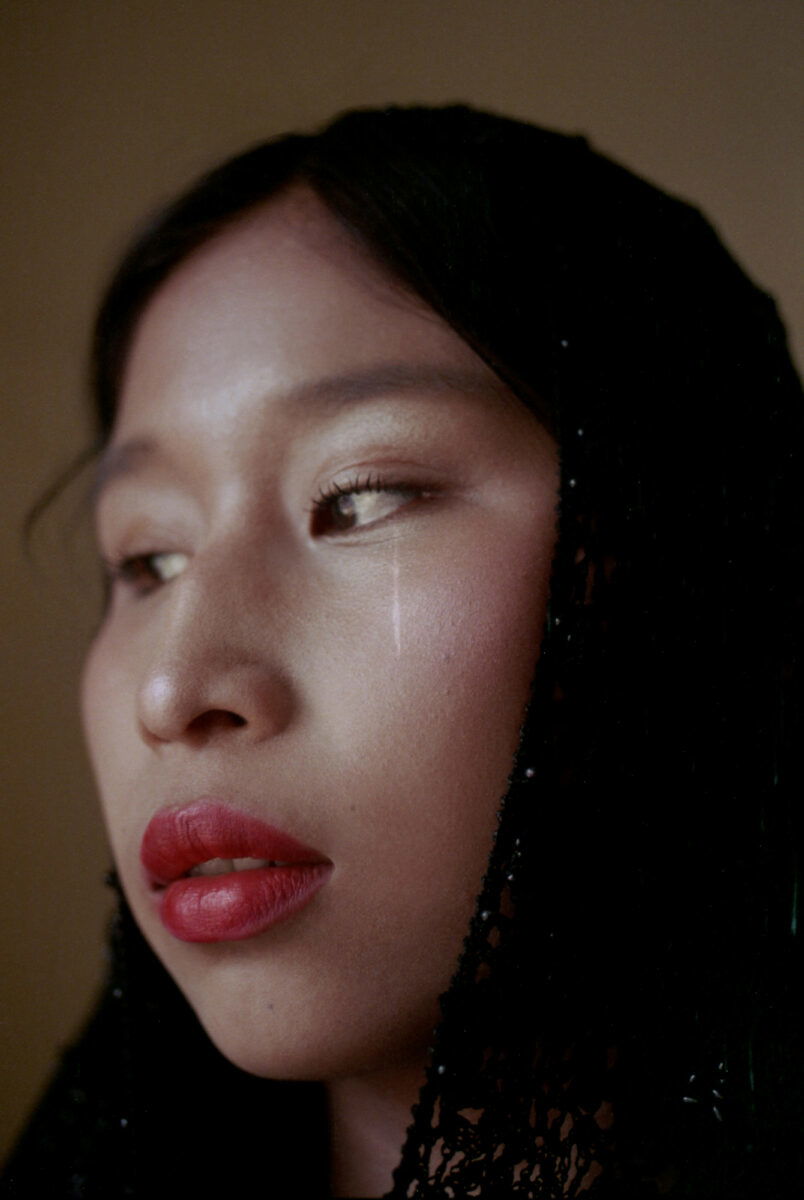 Portrait by Marisol Mendez. Woman crying in black veil with red lipstick.