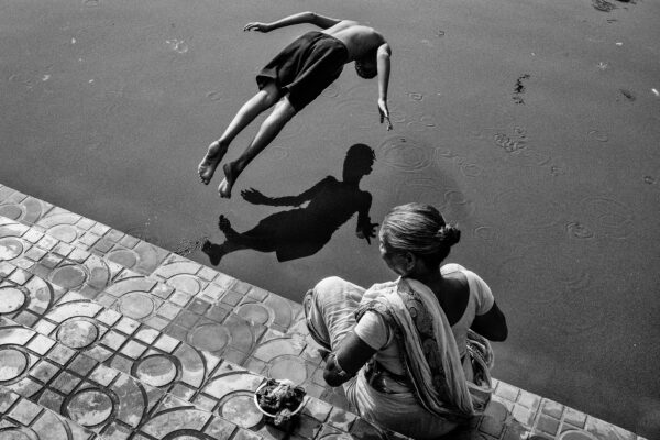 black and white of a boy diving in water in Kolkata, India by Subhran Karmakar