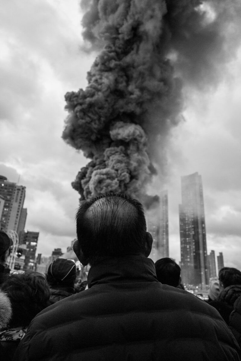 black and white street photo of man and smoke in South Korea by Jihhoon Kim